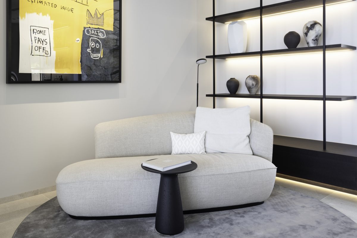 Project Goya – Open-plan interior with natural wood accents, neutral tones, designer chairs, and sculptural lighting in a contemporary Mediterranean style.